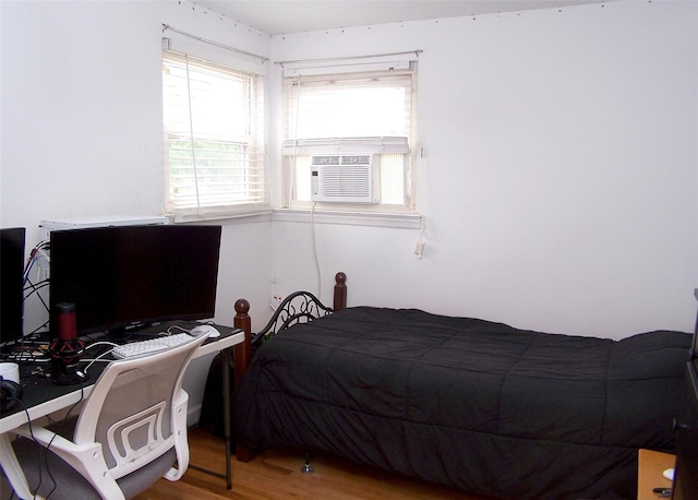 13 Lark Dr, Centereach, NY 11720 - bedroom with cooling unit, wood finished floors, and a desk