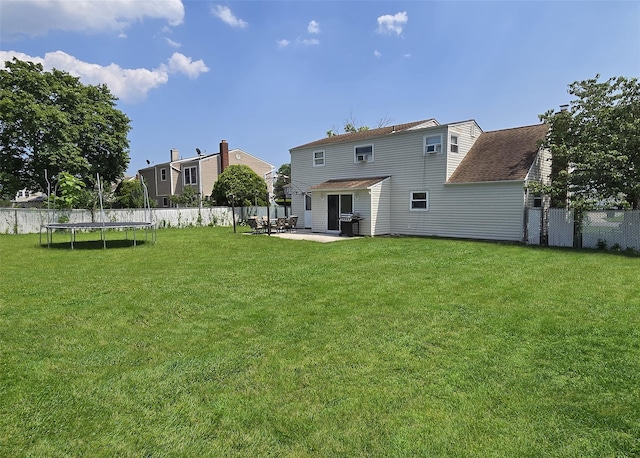 13 Lark Dr, Centereach, NY 11720 - back of house with a trampoline, a patio area, a fenced backyard, and a shingled roof