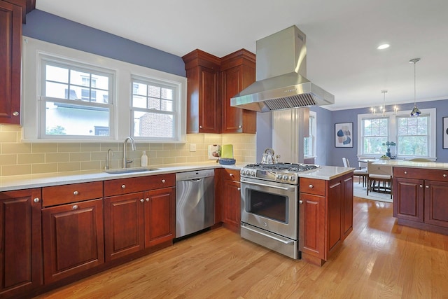 48 Faneuil Pl, New Rochelle, NY 10801 - kitchen with appliances with stainless steel finishes, wall chimney exhaust hood, light wood-type flooring, light countertops, and a peninsula