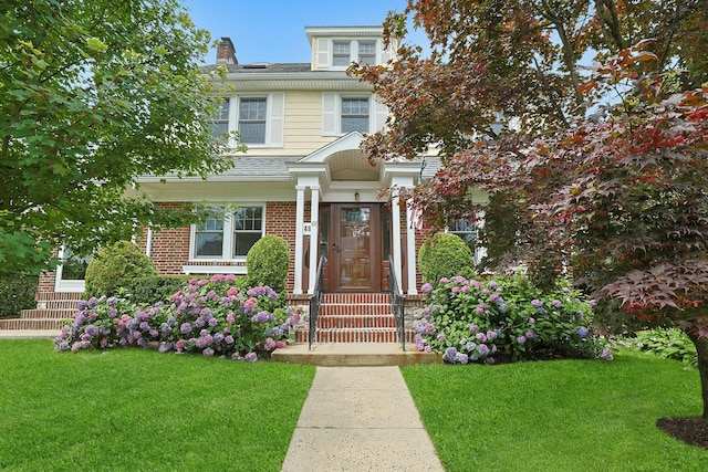 48 Faneuil Pl, New Rochelle, NY 10801 - view of front of property with a front lawn, brick siding, a chimney, and a shingled roof