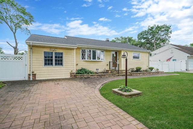 10 Harrison St, Brentwood, NY 11717 - view of front of property with a gate, a patio area, roof with shingles, and decorative driveway