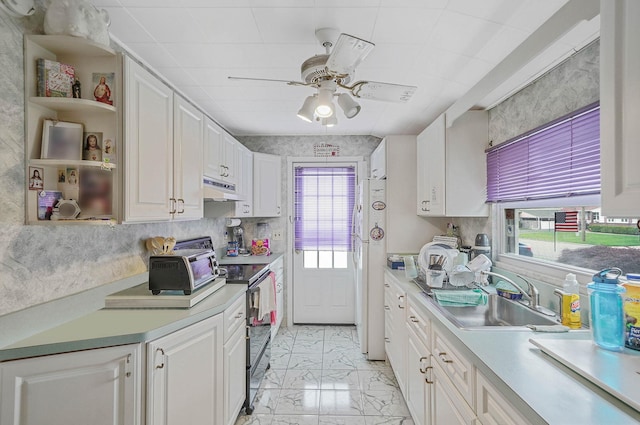 10 Harrison St, Brentwood, NY 11717 - kitchen with electric stove, under cabinet range hood, light marble finish flooring, and white cabinetry