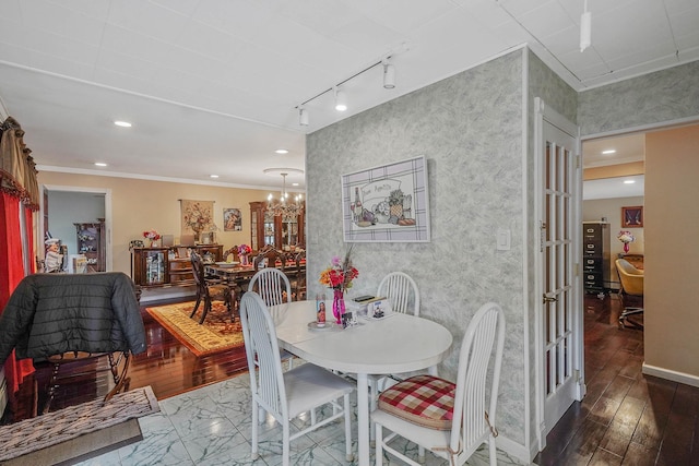 10 Harrison St, Brentwood, NY 11717 - dining area with hardwood / wood-style flooring, rail lighting, a chandelier, crown molding, and wallpapered walls