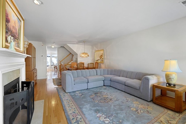 23 Bridge Ln Unit 23, Haverstraw, NY 10927 - living area with light wood-type flooring, a fireplace, stairs, recessed lighting, and a chandelier