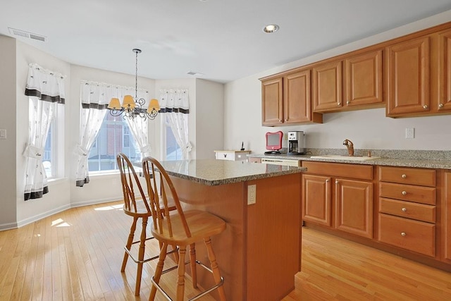23 Bridge Ln Unit 23, Haverstraw, NY 10927 - kitchen featuring light wood finished floors, a kitchen island, brown cabinets, a chandelier, and recessed lighting