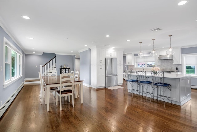 14 Ridge Dr E, Roslyn, NY 11576 - dining area with baseboard heating, crown molding, dark wood-type flooring, recessed lighting, and stairs