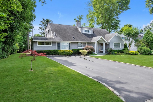 14 Ridge Dr E, Roslyn, NY 11576 - view of front of property with a chimney, a front lawn, and a shingled roof
