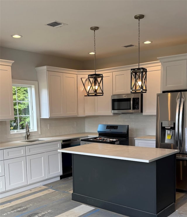 47 Sheridan Ave, Congers, NY 10920 - kitchen with stainless steel appliances, light countertops, a center island, decorative backsplash, and hanging light fixtures