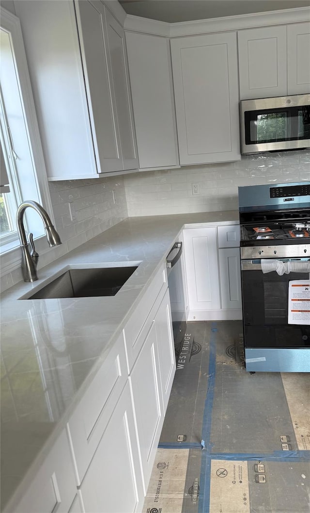 47 Sheridan Ave, Congers, NY 10920 - kitchen with stainless steel appliances, tasteful backsplash, white cabinetry, and light stone counters