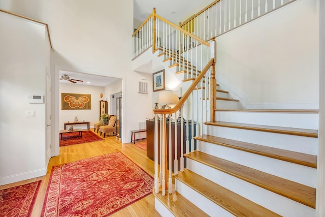 212A Lower Sheep Pasture Rd, East Setauket, NY 11733 - stairs with wood finished floors, a high ceiling, and ceiling fan
