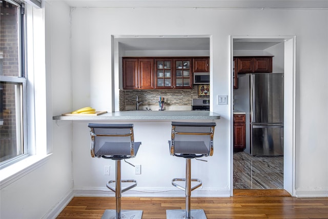 105-25 67th Rd Unit 5G, Forest Hills, NY 11375 - bar featuring stainless steel appliances, tasteful backsplash, and wood finished floors