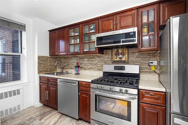 105-25 67th Rd Unit 5G, Forest Hills, NY 11375 - kitchen featuring appliances with stainless steel finishes, radiator, light countertops, and decorative backsplash
