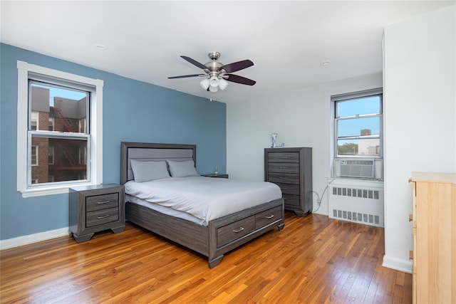 105-25 67th Rd Unit 5G, Forest Hills, NY 11375 - bedroom with radiator, light wood-style flooring, cooling unit, and a ceiling fan