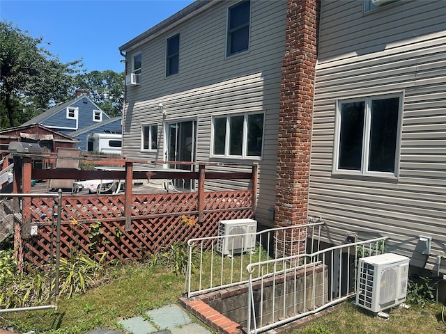 14 Eastwood Dr, North Babylon, NY 11703 - back of property with a wooden deck and cooling unit