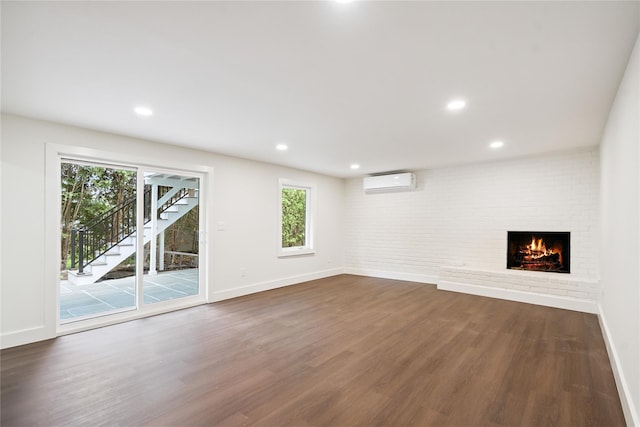 43 Acorn Ln, Plainview, NY 11803 - unfurnished living room featuring a wall mounted AC, a brick fireplace, dark wood-style floors, stairway, and recessed lighting