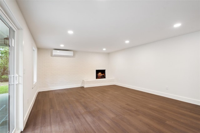 43 Acorn Ln, Plainview, NY 11803 - unfurnished living room featuring a wall mounted air conditioner, dark wood-type flooring, a brick fireplace, recessed lighting, and brick wall