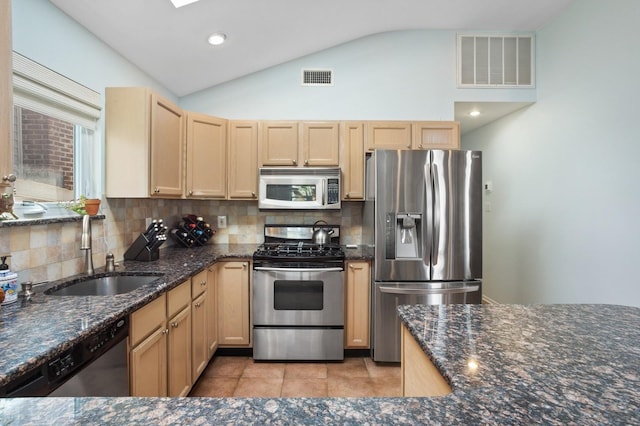101 Connecticut Ave, Long Beach, NY 11561 - kitchen featuring appliances with stainless steel finishes, lofted ceiling, tasteful backsplash, light brown cabinets, and dark stone countertops