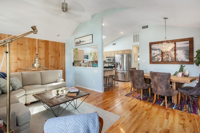 101 Connecticut Ave, Long Beach, NY 11561 - living room featuring vaulted ceiling, light wood-style flooring, a chandelier, and a ceiling fan