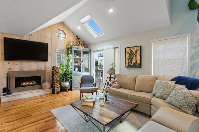 101 Connecticut Ave, Long Beach, NY 11561 - living room with a skylight, wood finished floors, vaulted ceiling, a warm lit fireplace, and wood walls