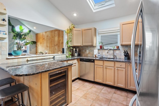 101 Connecticut Ave, Long Beach, NY 11561 - kitchen featuring appliances with stainless steel finishes, beverage cooler, a skylight, lofted ceiling, and backsplash