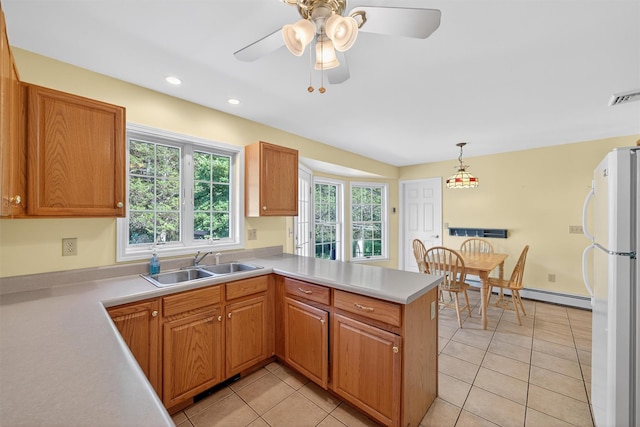 81 Hambletonian Rd, Chester, NY 10918 - kitchen with freestanding refrigerator, a peninsula, light countertops, light tile patterned floors, and decorative light fixtures