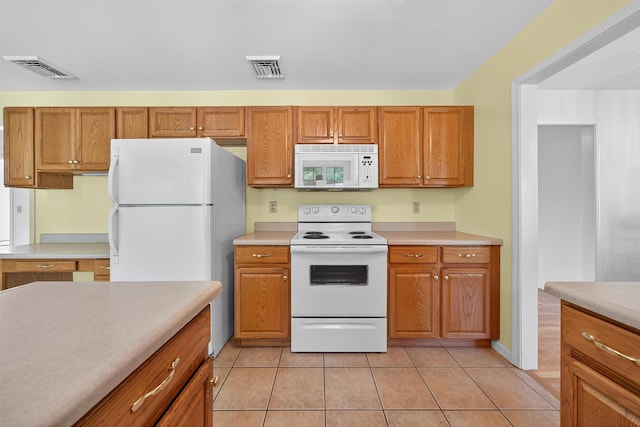 81 Hambletonian Rd, Chester, NY 10918 - kitchen featuring white appliances, light countertops, light tile patterned flooring, and brown cabinetry