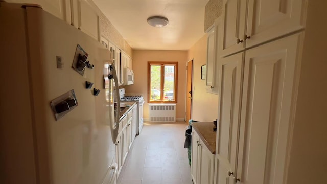 61-56 70th St, Middle Village, NY 11379 - kitchen with white appliances and radiator