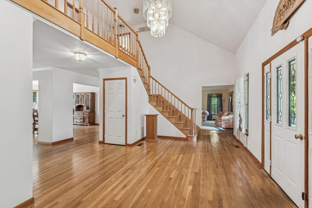 4 Springview Ct, East Patchogue, NY 11772 - entryway with stairway, light wood finished floors, high vaulted ceiling, and a chandelier