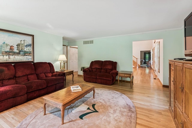4 Springview Ct, East Patchogue, NY 11772 - living area featuring light wood-type flooring, ornamental molding, and stairs