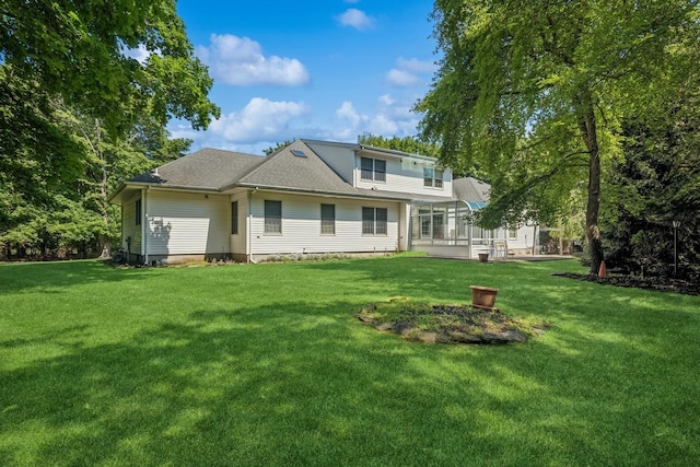 4 Springview Ct, East Patchogue, NY 11772 - rear view of house featuring a lawn, a sunroom, and roof with shingles
