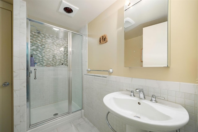 110 Read Rd, Red Hook, NY 12571 - bathroom featuring a shower stall, tile walls, wainscoting, and marble look tile flooring