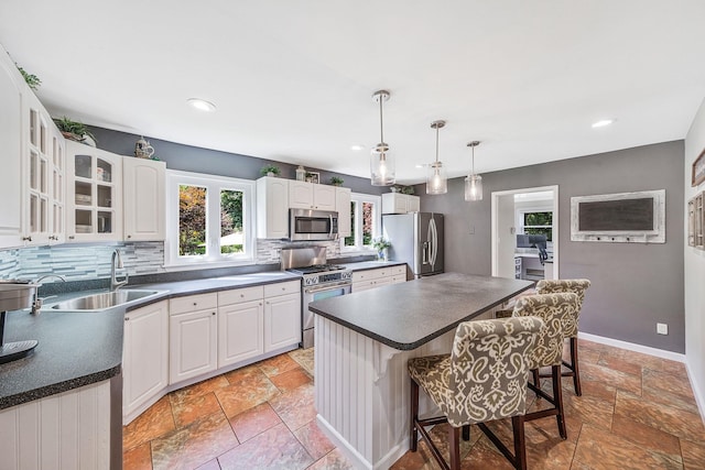 7 Simon Ct, East Northport, NY 11731 - kitchen featuring appliances with stainless steel finishes, stone tile floors, a breakfast bar area, dark countertops, and decorative backsplash