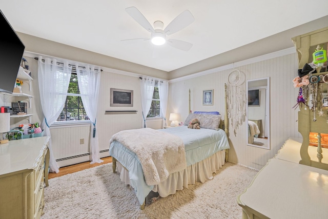 7 Simon Ct, East Northport, NY 11731 - bedroom featuring a baseboard heating unit, light wood-type flooring, and ceiling fan