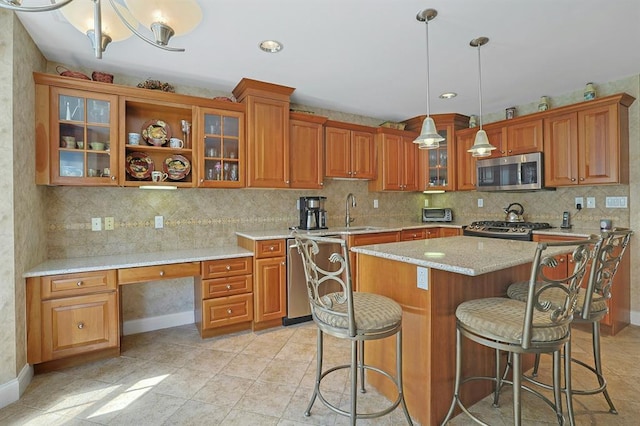27 Bridge Ln, Haverstraw, NY 10927 - kitchen with appliances with stainless steel finishes, brown cabinetry, backsplash, a kitchen bar, and a center island
