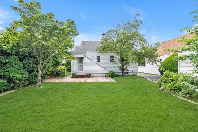 68 Moore St, New Hyde Park, NY 11040 - back of house featuring a lawn, a chimney, and a shingled roof