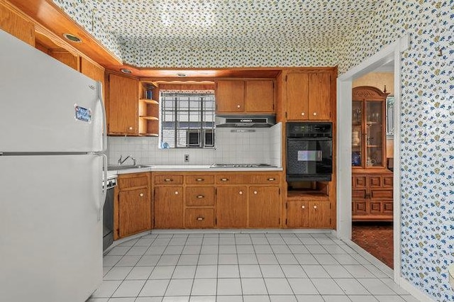 7318 180th St, Fresh Meadows, NY 11366 - kitchen featuring freestanding refrigerator, oven, wallpapered walls, range hood, and brown cabinetry