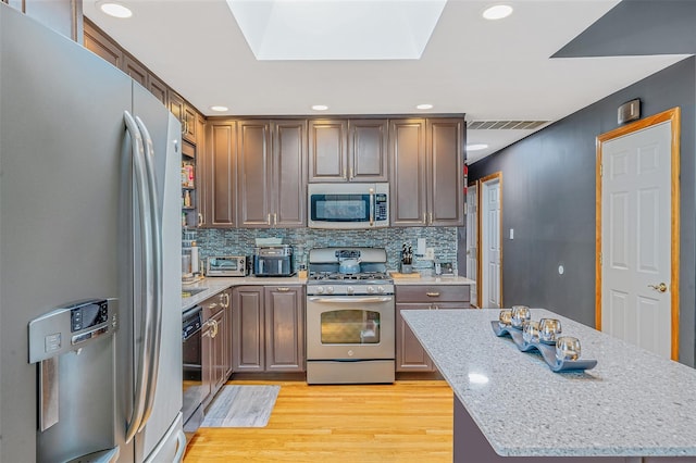 41 W 21st St, Deer Park, NY 11729 - kitchen with stainless steel appliances, light wood-style floors, recessed lighting, backsplash, and light stone countertops
