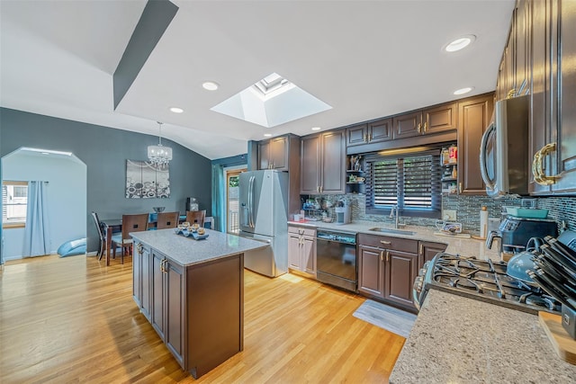 41 W 21st St, Deer Park, NY 11729 - kitchen with appliances with stainless steel finishes, a skylight, a center island, decorative backsplash, and light wood-style floors