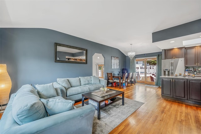 41 W 21st St, Deer Park, NY 11729 - living room with light wood finished floors, lofted ceiling, a chandelier, and arched walkways