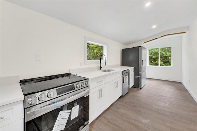 8 Pioneer Trl, Monroe, NY 10950 - kitchen featuring appliances with stainless steel finishes, lofted ceiling, light countertops, light wood finished floors, and white cabinetry