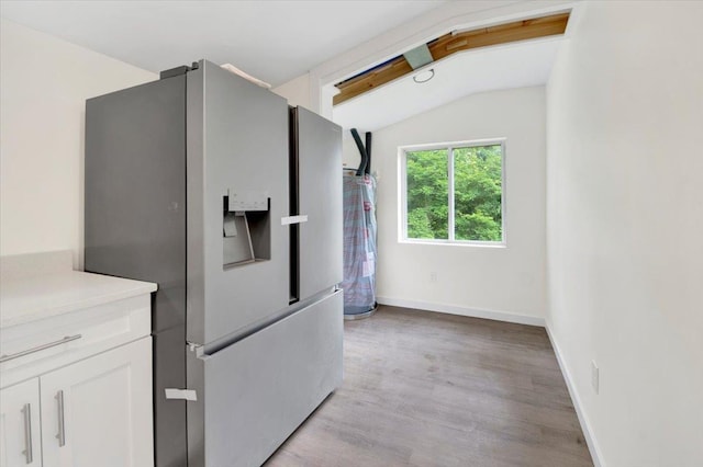 8 Pioneer Trl, Monroe, NY 10950 - kitchen featuring stainless steel fridge with ice dispenser, lofted ceiling, white cabinetry, light wood-type flooring, and light countertops