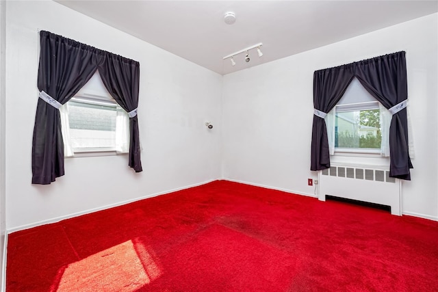 245 E Seaman Ave, Freeport, NY 11520 - carpeted empty room with radiator heating unit, rail lighting, and a smoke detector