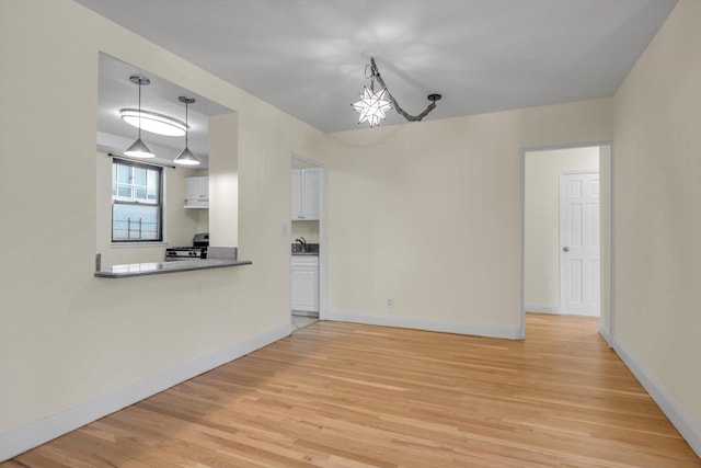 4705 Henry Hudson Pkwy W Unit 1J, Bronx, NY 10471 - unfurnished living room featuring light wood-style floors and a chandelier