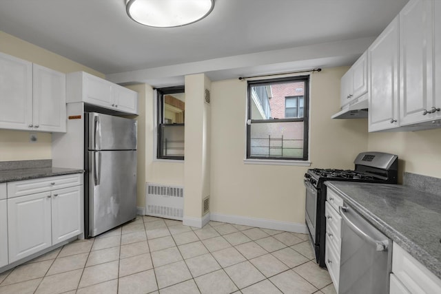 4705 Henry Hudson Pkwy W Unit 1J, Bronx, NY 10471 - kitchen with appliances with stainless steel finishes, radiator heating unit, dark countertops, under cabinet range hood, and white cabinetry