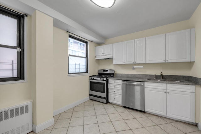 4705 Henry Hudson Pkwy W Unit 1J, Bronx, NY 10471 - kitchen featuring stainless steel appliances, radiator, under cabinet range hood, white cabinetry, and dark stone counters