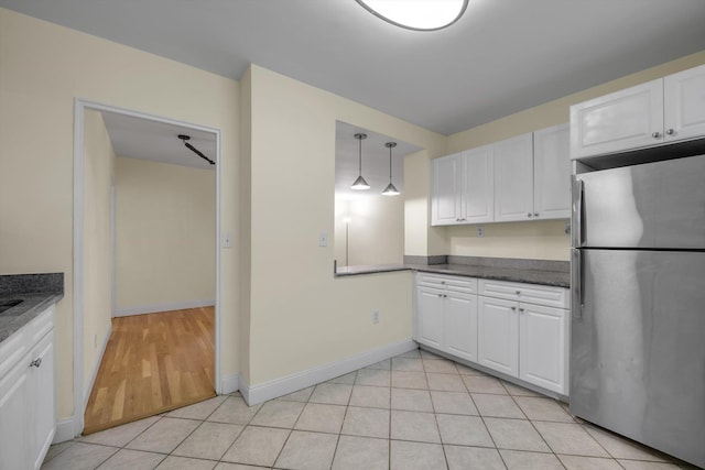 4705 Henry Hudson Pkwy W Unit 1J, Bronx, NY 10471 - kitchen featuring freestanding refrigerator, white cabinetry, dark countertops, decorative light fixtures, and light tile patterned flooring