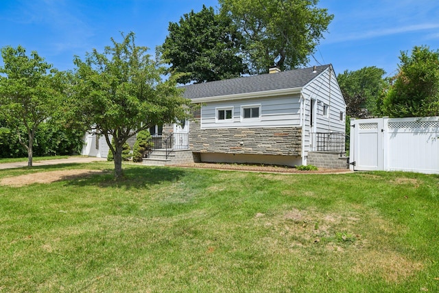 43 Walton St, Brentwood, NY 11717 - view of front of house with stone siding, a gate, and a chimney