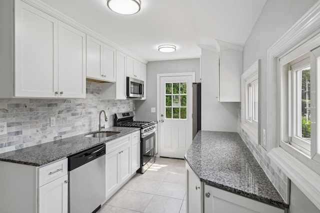 43 Walton St, Brentwood, NY 11717 - kitchen featuring stainless steel appliances, decorative backsplash, white cabinetry, and dark stone counters