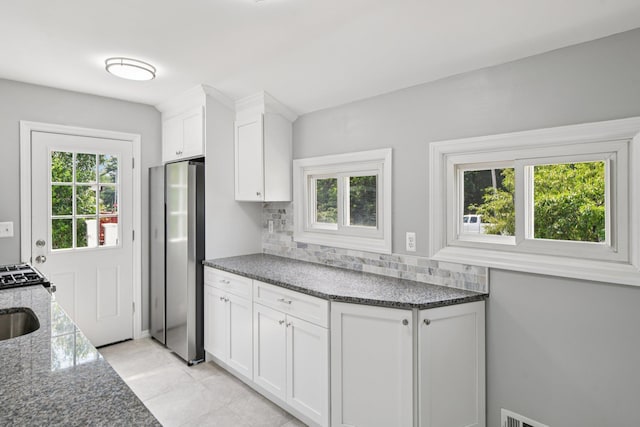 43 Walton St, Brentwood, NY 11717 - kitchen featuring freestanding refrigerator, healthy amount of natural light, backsplash, and white cabinets
