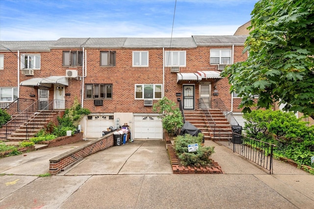 51-23 71st St, Woodside, NY 11377 - townhome / multi-family property featuring concrete driveway, an attached garage, brick siding, and a shingled roof